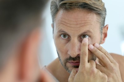 Man putting in contact lens
